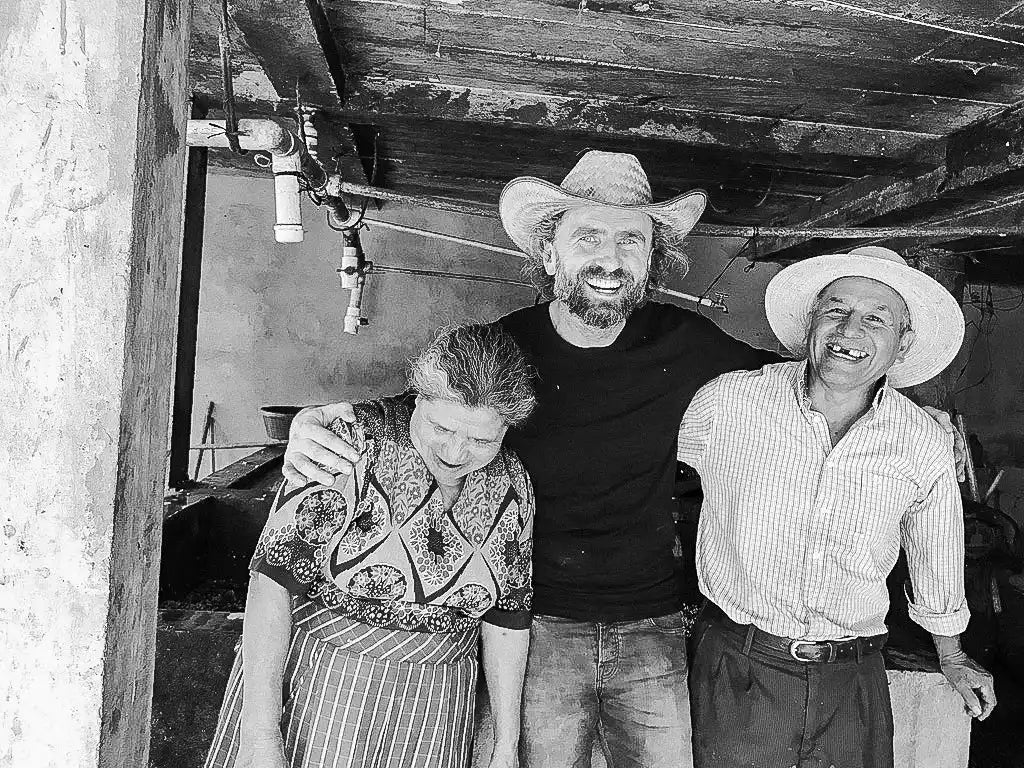 Three smiling people wearing hats.